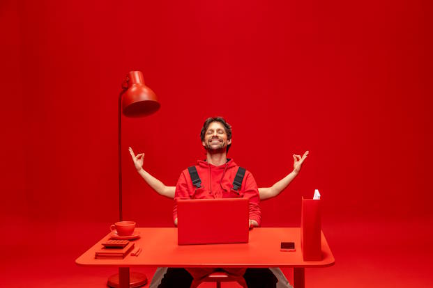 Bouwvakker achter een rode laptop in een rode kamer